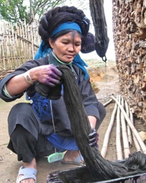 Người phụ nữ Hà Nhì đen đang nhuộm mái tóc giả.